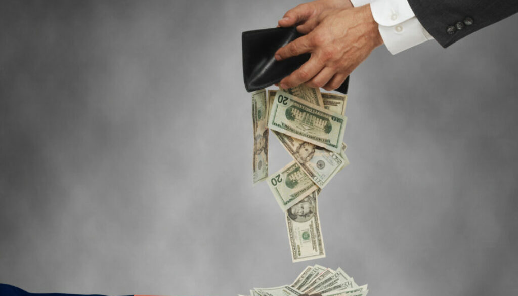 Hands giving money to a patriotic hand to show Tax Day
